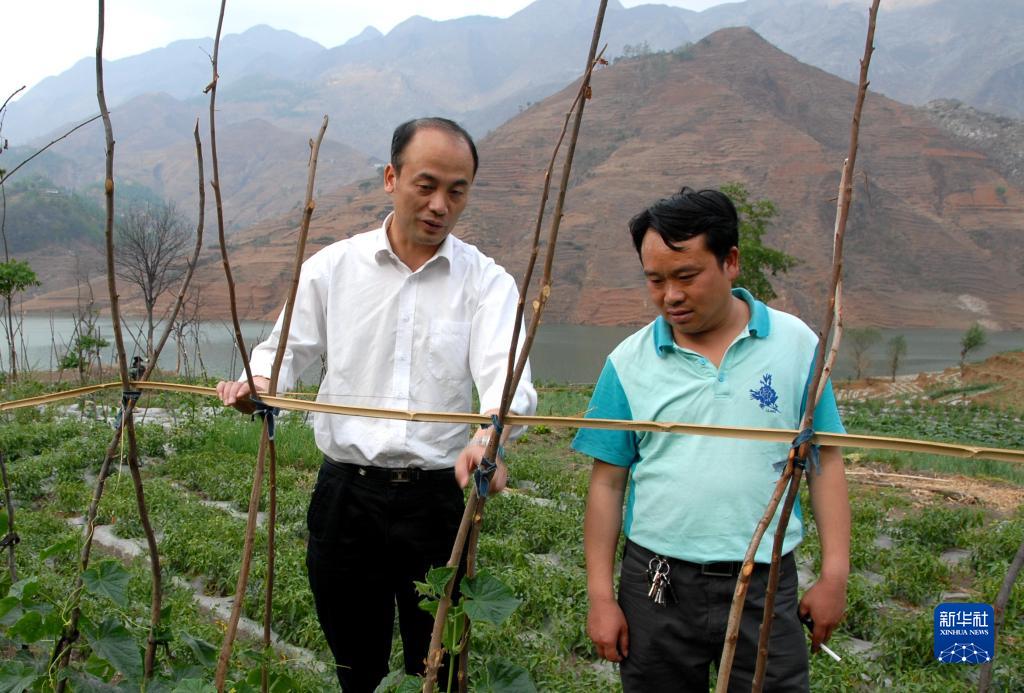 姜仕坤（左）在贵州晴隆县长流乡与村民交流（资料照片）。新华社发